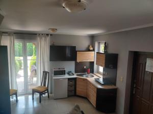 a small kitchen with a sink and a microwave at Sun Village Domki in Stegna +16 photos