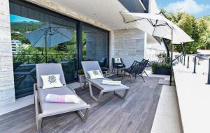 a patio with two chairs and two umbrellas at 2 Bedroom Nice Home In Icici in Ičići +19 photos