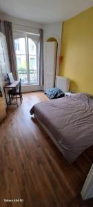 a bedroom with a bed and a desk and a window at Le Fiacre in Nancy
