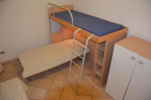 ブドーニにあるMelania Tanaunellaの二段ベッド1組、デスクが備わる小さな客室です。