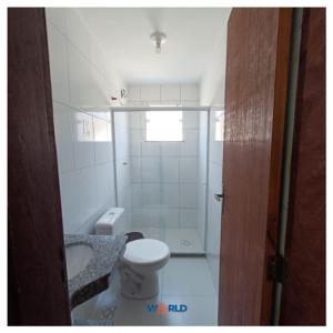 a white bathroom with a toilet and a sink at Pousada Estrela Mares 307 in Cabo Frio