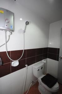 a bathroom with a shower and a toilet in it at Phoonsab Hostel in Phitsanulok