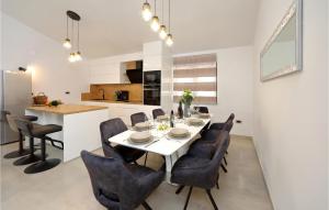 a kitchen and dining room with a white table and chairs at Awesome Home In Starigrad Paklenica in Starigrad-Paklenica