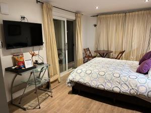a bedroom with a bed and a flat screen tv at Loma de las Maravillas 2 in Curacaví