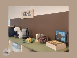 a counter top with a coffee maker and a box of fruit at Elmas Room in Elmas
