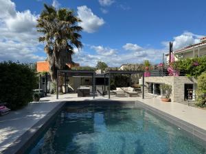 una piscina nel cortile di una casa di Chez Isa - avec jacuzzi intérieur et piscine chauffée a Gigean
