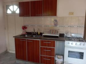 a kitchen with a sink and a stove at Alojamiento temporario 1 in Villa Sarmiento