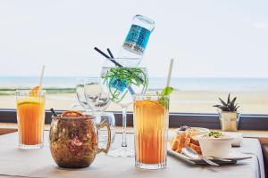 a table with drinks and a plate of food at La Cremaillere Hôtel-Restaurant in Courseulles-sur-Mer