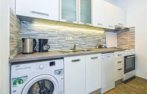 a kitchen with a washing machine and a sink at Three-Bedroom Apartment In Ostrvica in Ostrvica
