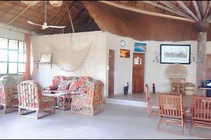 a living room with a couch and a table and chairs at Charming house with private pool in Cap Skirring in Cap Skirring