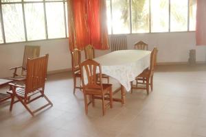 a dining room with a table and chairs and windows at Charming house with private pool in Cap Skirring in Cap Skirring