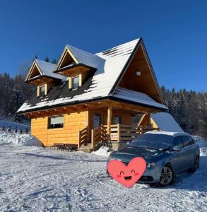 einem vor einem Blockhaus geparkt in der Unterkunft Domek Zakopiański Widok in Zakopane