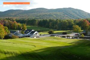 una vista aérea de un campo de golf con montañas en el fondo en Cabin in the Woods, en Hillsborough