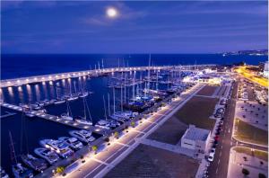 un puerto deportivo nocturno con un puente y barcos en Comfort Hotel Apartments, en Rodas