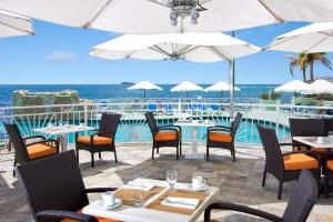 a restaurant with tables and chairs and a view of the ocean at Oyster Bay Beach Resort in Dawn Beach