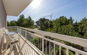 a balcony with a chair and a view of a street at Apartment Vojskovo Croatia in Lokva Rogoznica