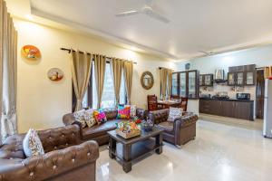 a living room with leather couches and a table at Alaya Stays Cozy Nest 2 BHK Cottage with Garden in Bhīm Tāl