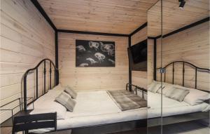 a bedroom with two beds in a room with wooden walls at Beautiful Home In Pogorzelica in Pogorzelica