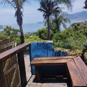 a wooden bench with a view of the ocean at Bangalô Vista Azul in Ilhabela