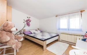 a small bedroom with a bed and a teddy bear at Cozy Apartment In Viskovo in Viskovo