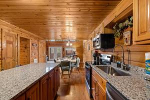 a kitchen with a sink and a dining room at NewListing 1mile Parkway, GameRoom, HotTub, BBQ, Sleeps 14, 5 Bedroom with attached Bath, PET Friendly in Pigeon Forge