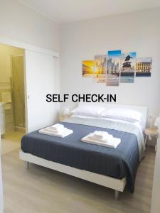 Un dormitorio con una cama con un cartel de auto check-in. en Biga Guest House - Intero appartamento Milano, en Milán