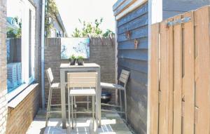 eine kleine Terrasse mit einem Tisch und Stühlen auf einem Gebäude in der Unterkunft Dophuisje in Egmond aan Zee