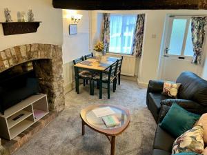 a living room with a table and a fireplace at Cottage in Wells in Wells