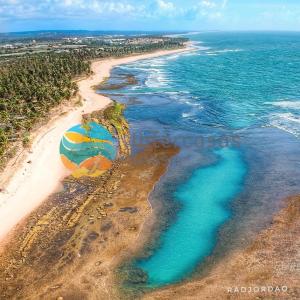 an aerial view of a beach with a beach ball at Villa Biarritz, Praia do Forte in Praia do Forte
