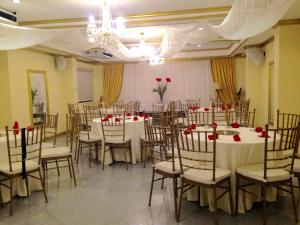 a banquet hall with tables and chairs with red roses at Spring Plaza Hotel in Dasmariñas