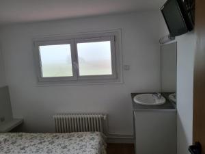 a small bedroom with a sink and a window at le pressoir in Boissise-le-Roi +4 photos