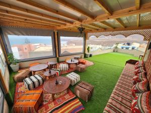 an outdoor patio with tables and chairs and a lawn at Tirazir House 4 in Mirleft