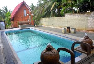 una piscina con due vasi accanto a una casa di Ciel Star Anuradhapura a Anuradhapura