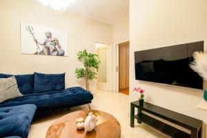 a living room with a blue couch and a table at The Parthenon Porch for Familys & Groups , 4BR ! in Athens