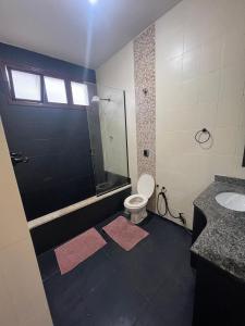 a bathroom with a shower and a toilet and a sink at Lindo Loft na Praia dos Sonhos in Itanhaém