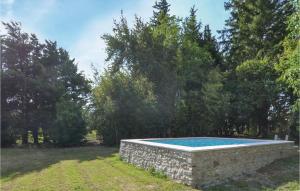 a stone swimming pool in a yard with trees at Lovely Home In Montbrison-Sur-Lez in Montbrison-sur-Lez