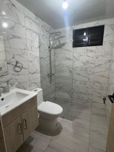 a bathroom with a shower and a toilet and a sink at Comfortable apartment in Los Mameyes