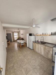 a kitchen with a table and a white refrigerator at Departamento con cochera cerca del centro en Mendoza in Mendoza