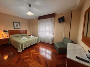 a bedroom with a bed and a desk and a chair at Hostal Merindades in Villarcayo