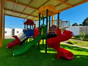 a playground with a slide in the grass at Los Ausoles Home with Jacuzzi, HotSprings Ahuachapán in Ahuachapán