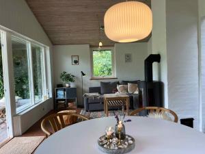 a living room with a table and a couch at Cosy Summer Cottage Glose To Sandy Beach! in Knebel