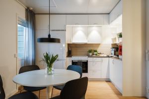 a small kitchen with a white table and chairs at Guestly Homes - 1BR Scandinavian Charm in Piteå