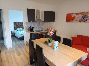 una cucina e una sala da pranzo con tavolo in legno e sedie di gîte dans endroit atypique a Flamets-Frétils