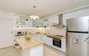 eine Küche mit weißen Schränken und einem Kühlschrank in der Unterkunft Three-Bedroom Holiday Home In Orasac in Orasac
