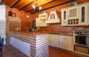 una cucina con mobili bianchi e un muro di mattoni di Gorgeous Home In Priego De Cordoba a Priego de Córdoba