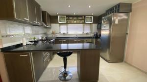 a kitchen with a stainless steel refrigerator and a counter at Urano Pinamar in Pinamar
