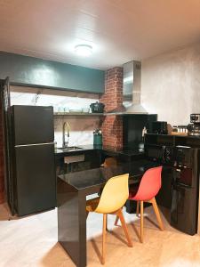 una cucina con bancone nero e 2 sedie di Blue Tulip - Rooms with Jacuzzi a Lapu Lapu City