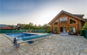 a swimming pool in front of a log house at Cozy Home In Prokike With Sauna in Prokike