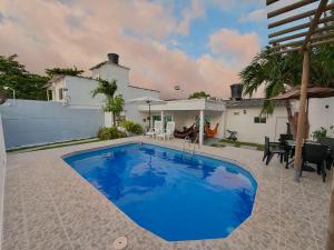 a large blue swimming pool in front of a house at Cabaña Doña Carmela in Santa Marta