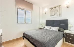 a bedroom with a large bed and two windows at Lovely Apartment In Torrevieja in Torrevieja
